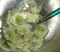 onions and celery in a silver bowl with a green spoon