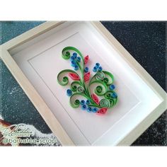 a paper quilled art work in a white frame with blue and pink flowers on it