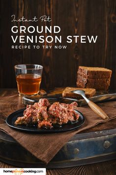 a black plate topped with meat next to two slices of bread and a glass of tea