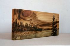 a wooden box with an image of a lake and trees in the woods on it