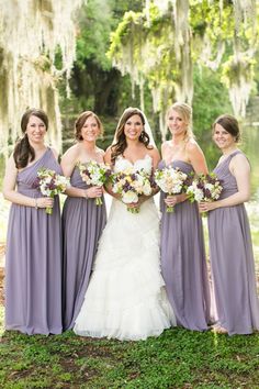 a group of women standing next to each other in front of a tree with flowers