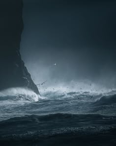 an ocean scene with waves crashing against the rocks and birds flying in the sky above