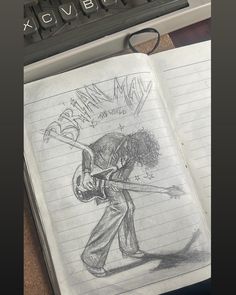 an open notebook with a drawing of a man holding a baseball bat on top of it