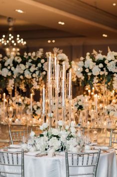 the tables are set with white flowers and candles