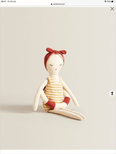 a small doll sitting on top of a white surface