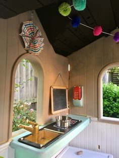 a kitchen with an oven, sink and hanging decorations