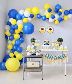 a party with balloons and decorations in blue, yellow and white colors is ready to be eaten