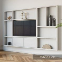 a white entertainment center with shelves and a flat screen tv mounted on it's wall