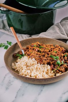 a bowl filled with rice and meat on top of a table