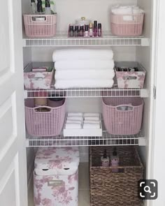 an organized closet with baskets and towels