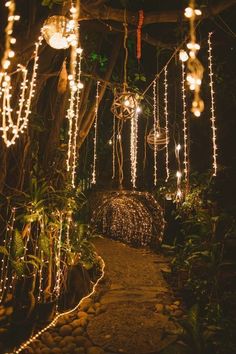 the lights are hanging from the trees in the garden at night, making it look like they're going to fall