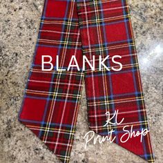 a red plaid neck tie with the words blanks on it in front of a granite countertop