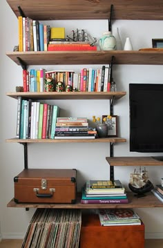 there is a tv and some books on the shelves