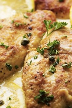 two pieces of chicken with lemon slices and parsley