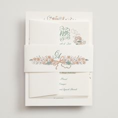 the wedding stationery is laid out on top of each other, with floral designs