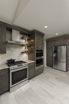 a kitchen with gray cabinets and stainless steel appliances