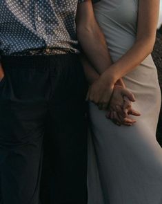 a man and woman standing next to each other with their arms around each other's shoulders