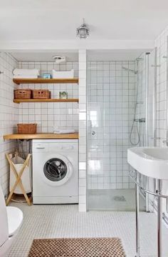 a washer and dryer in a bathroom with white tiles on the walls, flooring and shelving