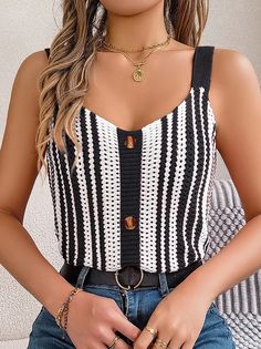 a woman wearing a black and white striped top with gold rings on her hand,