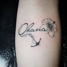 a tattoo with the word ohana written in cursive writing and a flower