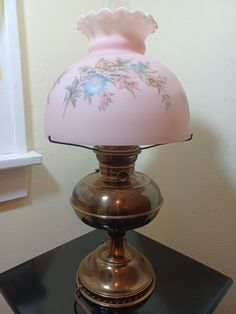 a pink lamp sitting on top of a black table