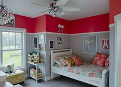 a bedroom with pink and gray walls, white bedding, and colorful pillows on it