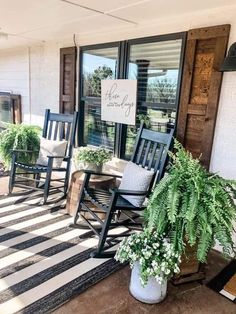 two rocking chairs sitting on the front porch with potted plants and a welcome sign