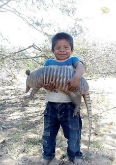 a young boy holding an armadia in front of the caption that says, i