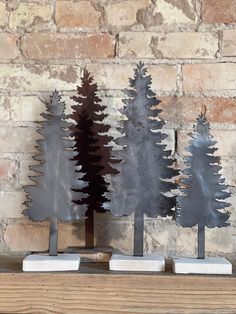 three metal trees sitting on top of a wooden table