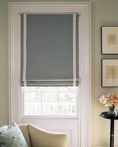 a living room filled with furniture and pictures on the wall next to a window covered in blinds