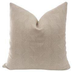 a beige pillow with a diamond pattern on the front and back, sitting on a white background