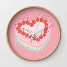 a pink clock with cherries on the top of it and a cake in the middle