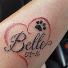 a tattoo with a dog's paw and name in the shape of a heart