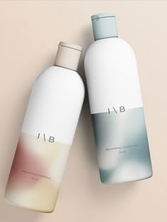 two bottles of shampoo sitting next to each other on top of a beige surface