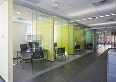 an empty office with glass walls and desks