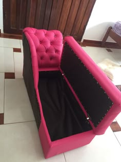 a pink and black couch sitting on top of a tiled floor