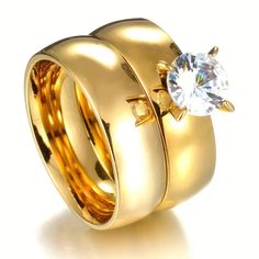 two gold wedding rings with a diamond on top