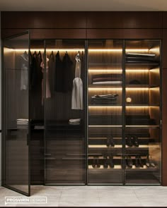 a walk in closet with glass doors and clothes on hangers