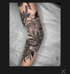 a woman's arm with flowers and butterflies tattoo on her left forearm, next to a gray background