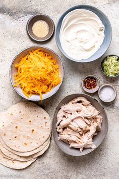 the ingredients to make chicken quesadilla laid out in bowls