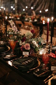 the table is set with candles, plates and place settings for an elegant dinner party