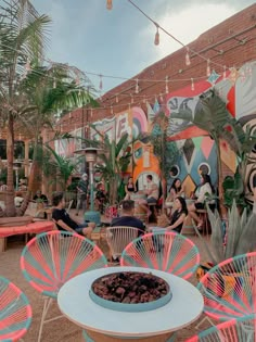 colorful chairs and tables in front of a mural