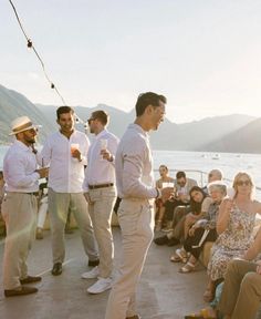 a group of men standing next to each other in front of a body of water