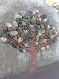 a tree made out of rocks on the side of a building