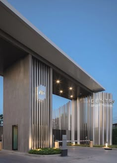 the entrance to an office building with metal slats on it's sides and lit up at night