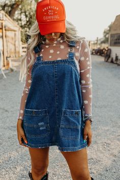 Introducing the must-have for any wardrobe: The Etta Dress. Made with durable denim and a boxy silhouette, this overall mini dress features a square neckline and detachable (and adjustable!) straps for ultimate style and comfort. The slightly distressed finish and western-inspired seam detail add a touch of unique flare. Courtney is wearing size small paired with the Daisy Mesh Top, American Cowgirl Trucker and Ariat Casanova Boots Jean Skirt Overalls Outfit, Football Party Outfit, Outside Outfits, Outfits For Nashville, California Cowgirl, Outfits 30s, American Cowgirl, Nfr Outfits, Modest Outfit Ideas