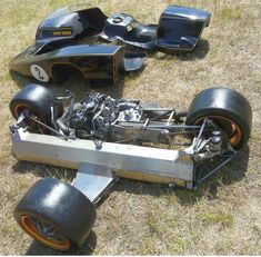 an old race car sitting on the ground with its front wheels removed from it's body