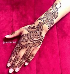 a woman's hand with henna tattoos on it