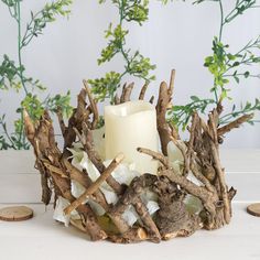 a candle is sitting on top of some driftwood and surrounded by small pieces of wood