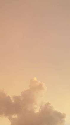 an airplane is flying high in the sky with clouds behind it and another plane on the ground